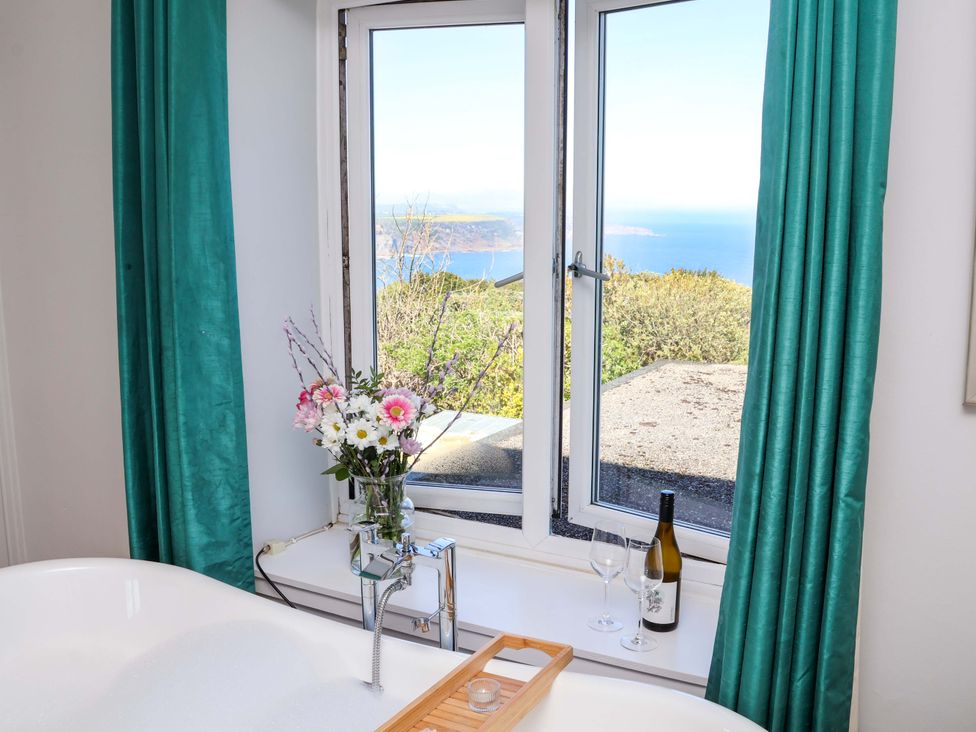 A bathroom with a bathtub and a view at Voebroch in Lythe