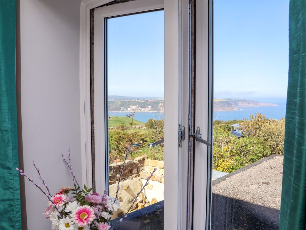 A window with flowers and a view at Voebroch in Lythe