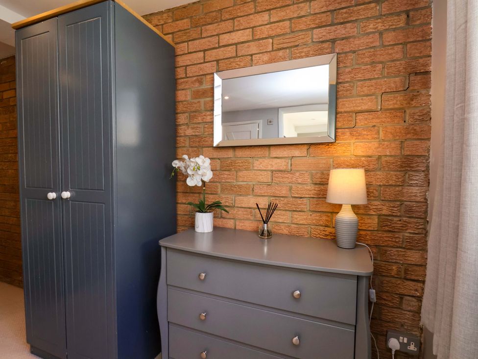 A bedroom with a grey wardrobe and dressing table at Voebroch in Lythe