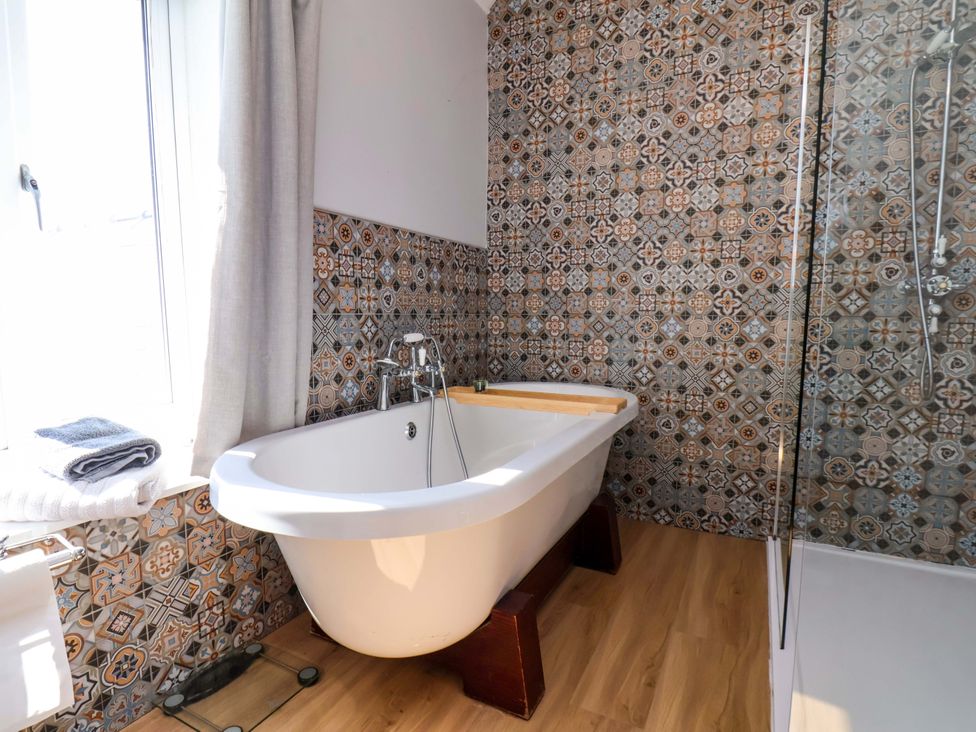 A bathroom with a bathtub and shower at Voebroch in Lythe