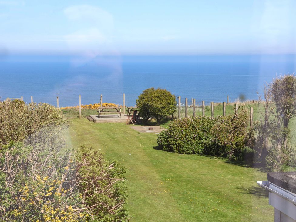 A garden with seating area and ocean view at Voebroch in Lythe