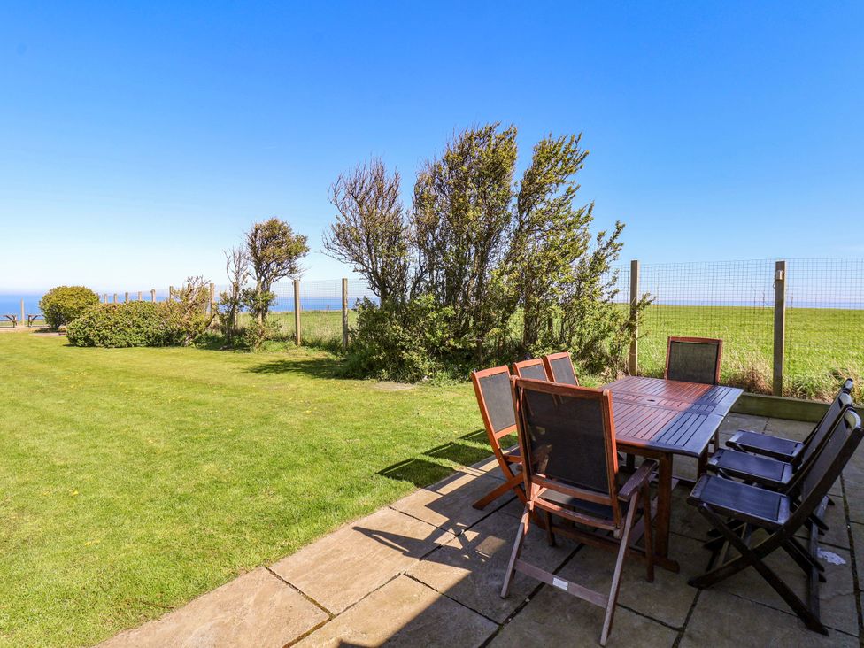 An outdoor dining area with a table and chairs at Voebroch in Lythe
