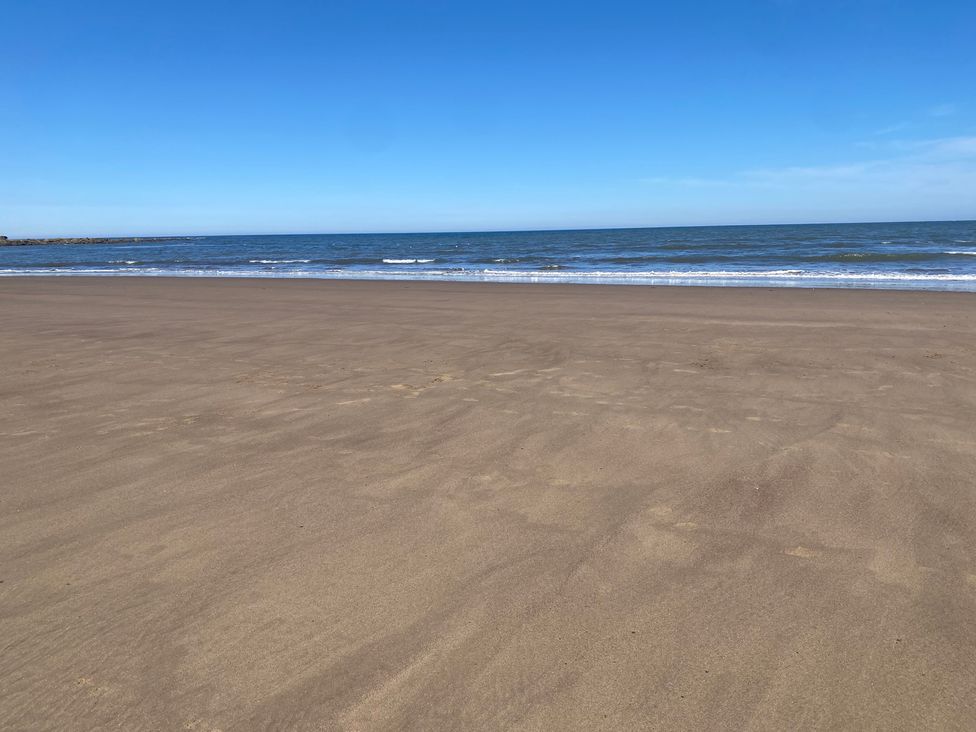 A beach with sand and ocean waves at Voebroch in Lythe