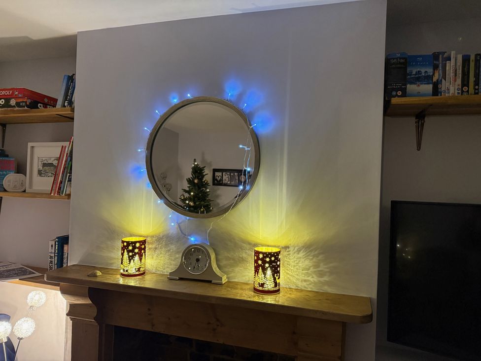A living room with a mirror and decorative light at Overchurch in Hythe