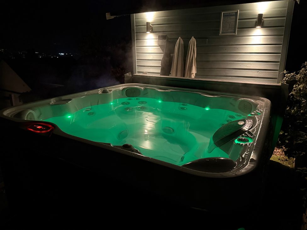 A hot tub with glowing lights and towels at Overchurch in Hythe