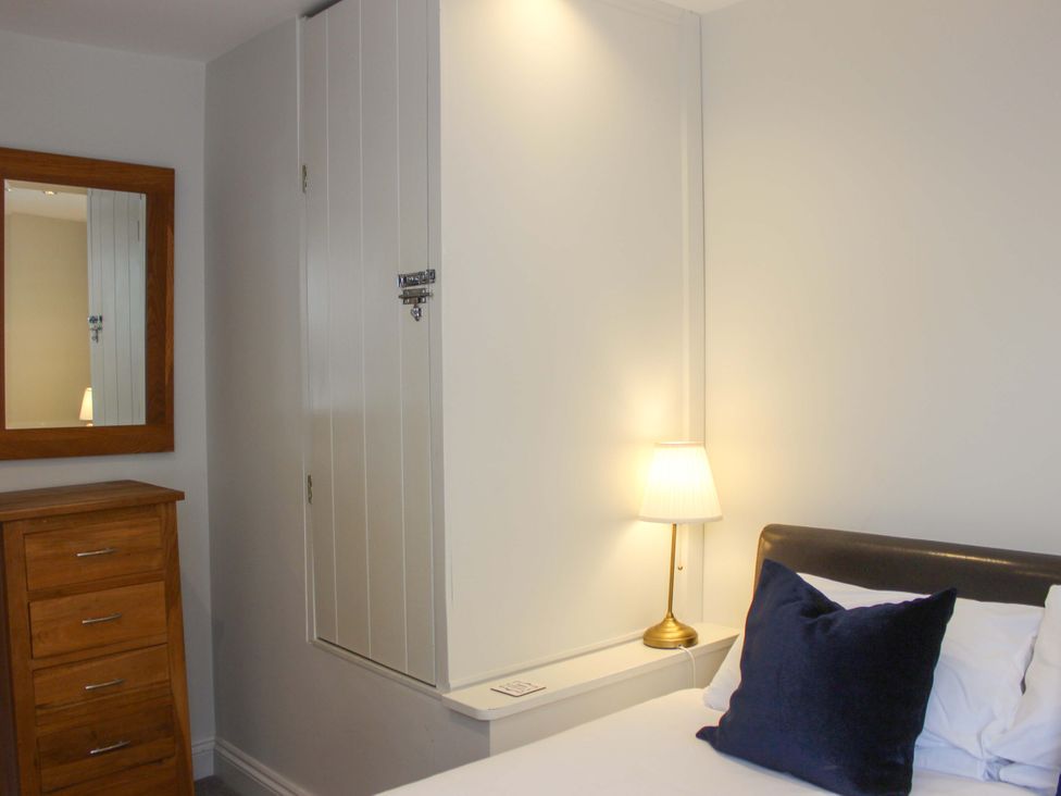 A bedroom with a chest of drawers and a wall cabinet at Simples in Dartmouth