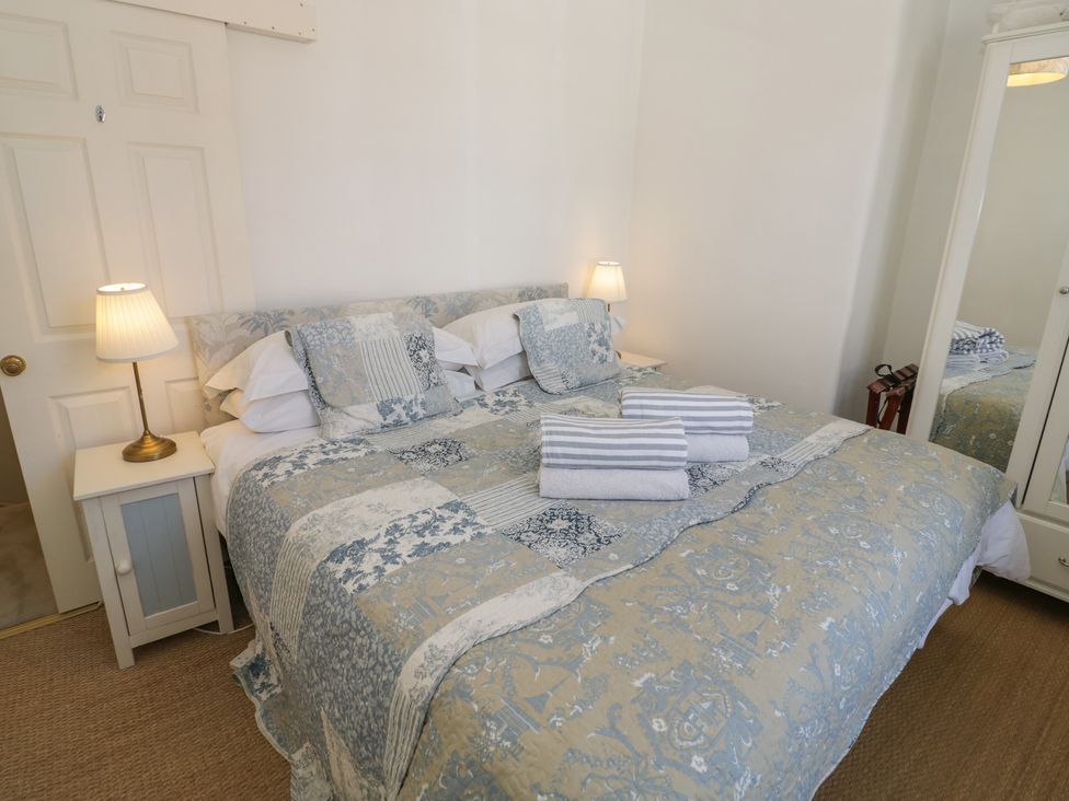 A bedroom with a bed and mirror at Heath Cottage Stratford-Upon-Avon