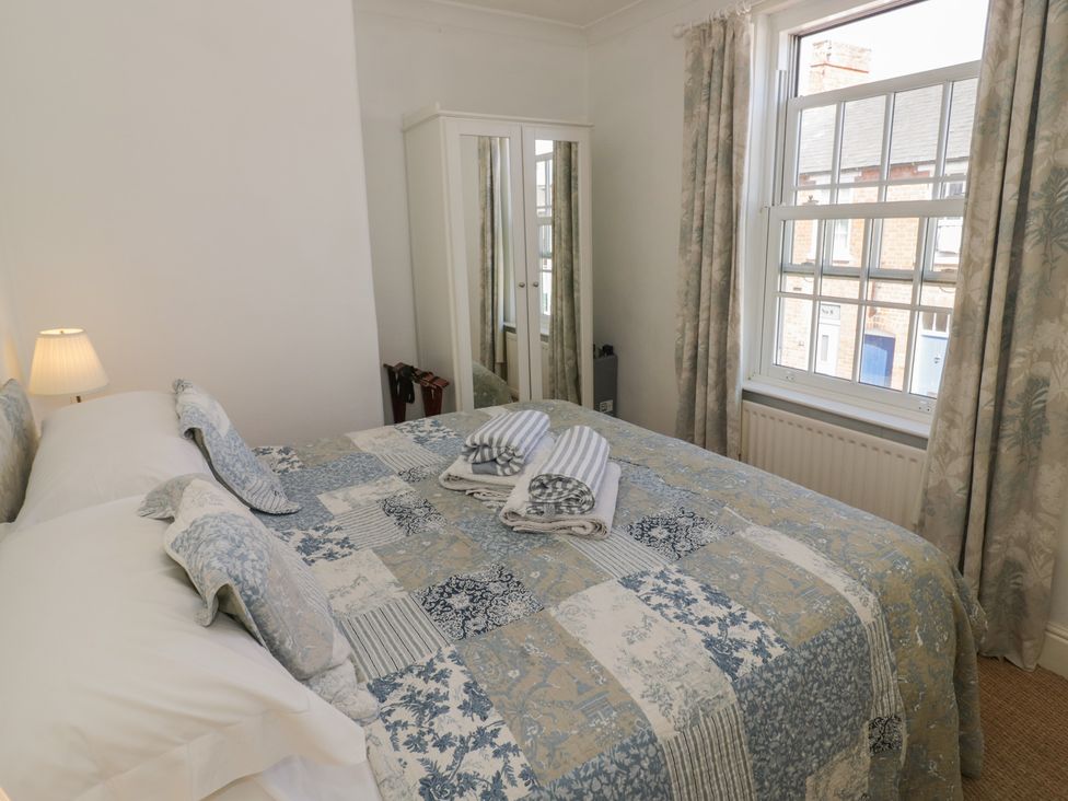 A bedroom with a bed and mirror cabinet at Heath Cottage in Stratford-Upon-Avon