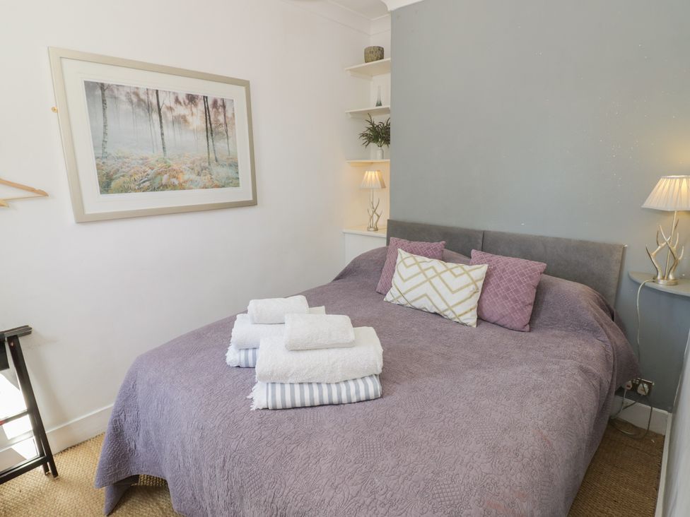 A bedroom with a bed and towels at Heath Cottage in Stratford-Upon-Avon