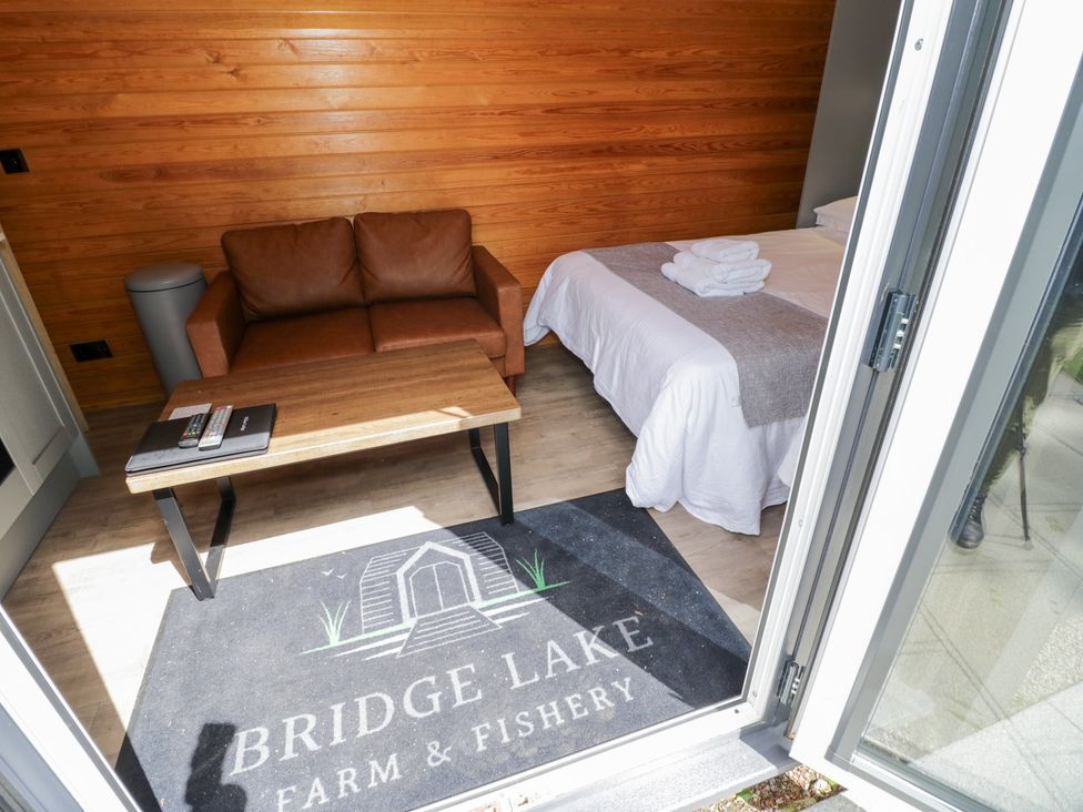 A room with a bed and a sofa at Willow Lodge At Bridge Lake Farm & Fishery Chacombe