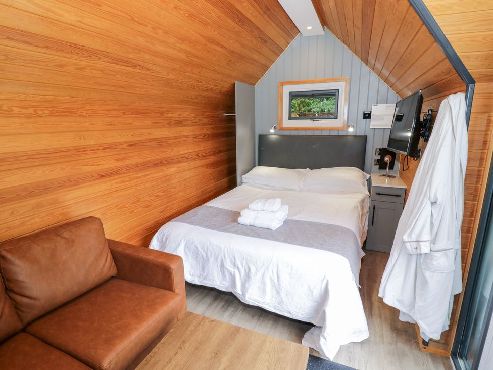 A bedroom with a bed and couch at Willow Lodge At Bridge Lake Farm & Fishery Chacombe