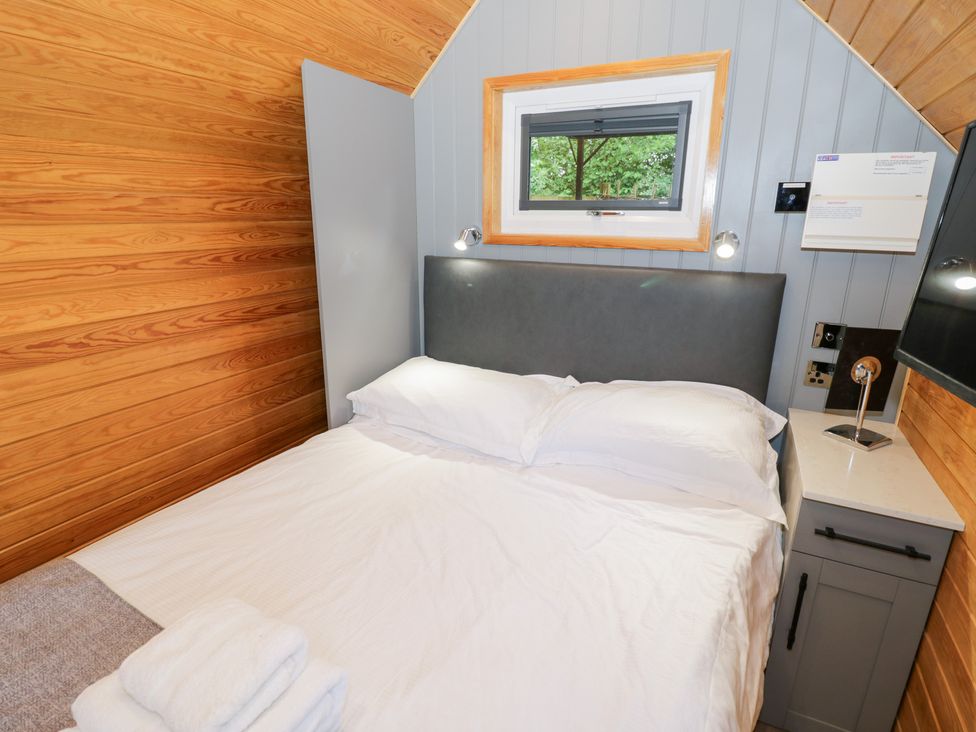 A bedroom with a bed and window at Willow Lodge At Bridge Lake Farm & Fishery, Chacombe
