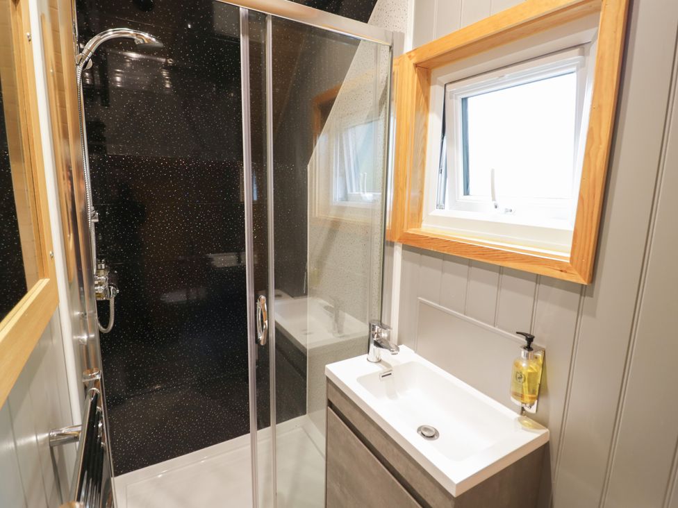 A bathroom with a shower and sink at Willow Lodge At Bridge Lake Farm & Fishery Chacombe