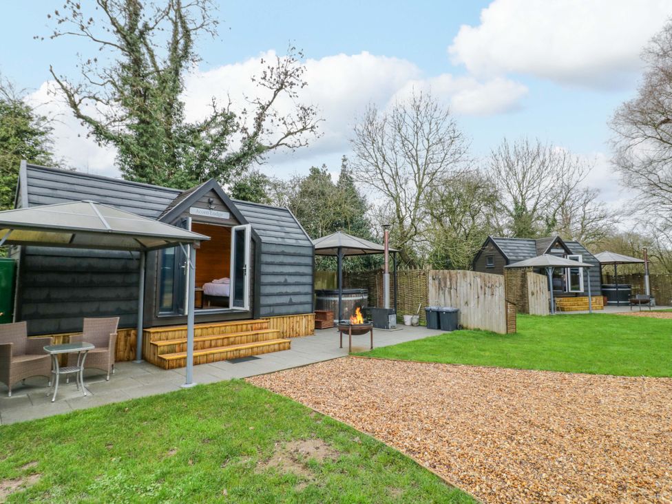 An outdoor area with cabins and seating at Willow Lodge At Bridge Lake Farm & Fishery in Chacombe