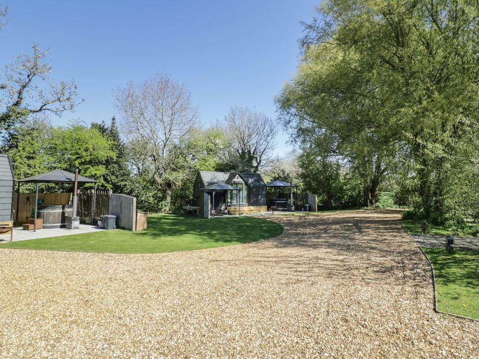 An outdoor area with a hot tub and seating at Willow Lodge At Bridge Lake Farm & Fishery Chacombe