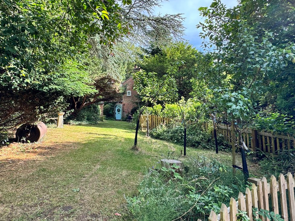 A garden with trees and a pathway at Sunny Cottage in Grantham