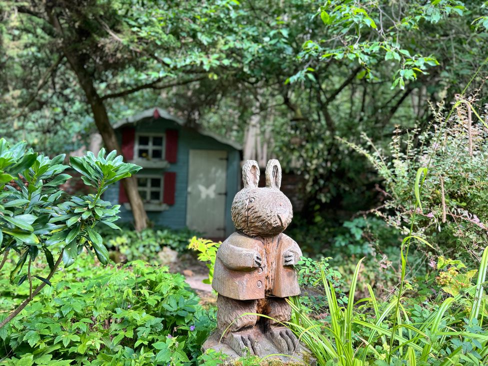A wooden rabbit statue in a garden at Sunny Cottage Grantham