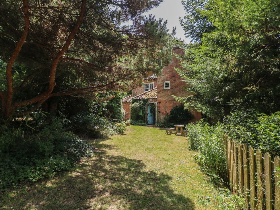 A house and garden with trees and a fence at Sunny Cottage in Grantham
