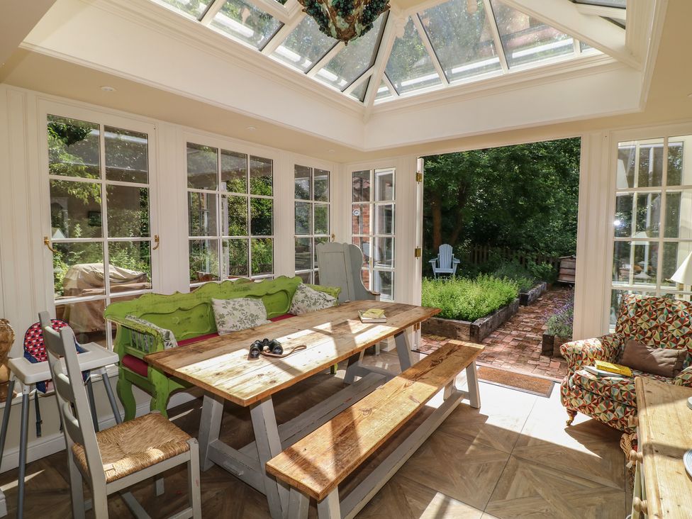A conservatory with a table and chairs at Sunny Cottage in Grantham