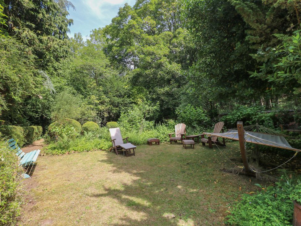 A garden with chairs and a hammock at Sunny Cottage in Grantham