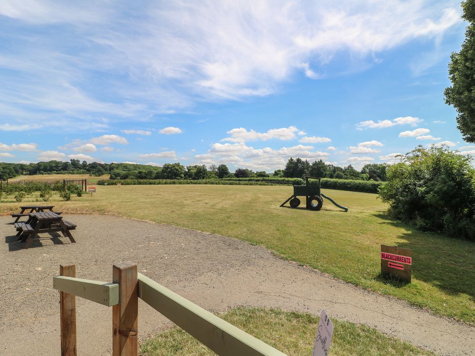 An outdoor area with a bench along a path and a cart at Sunny Cottage in Grantham