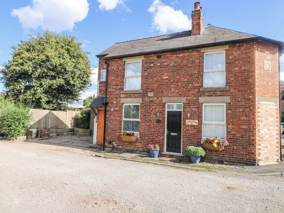 A brick house with flower pots at Corner House Cottage Mapperley Village