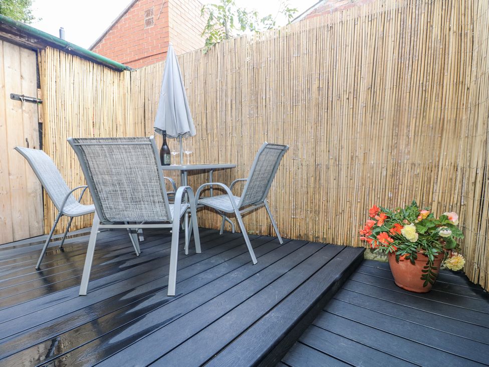 A garden patio with furniture and plants at Corner House Cottage in Mapperley Village