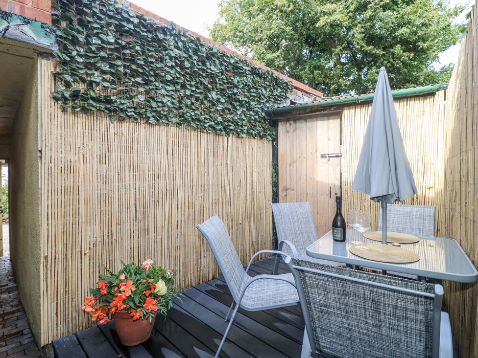 An outdoor area with a table and chairs at Corner House Cottage Mapperley Village