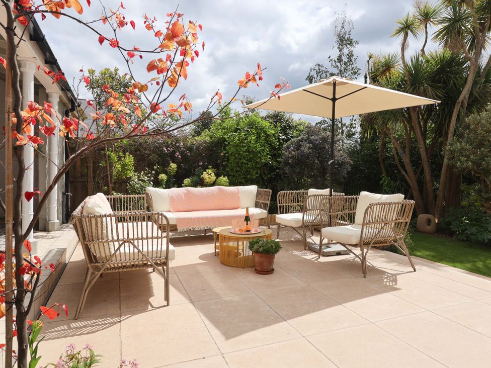 An outdoor seating area with furniture in the garden at Barnsley House Teignmouth