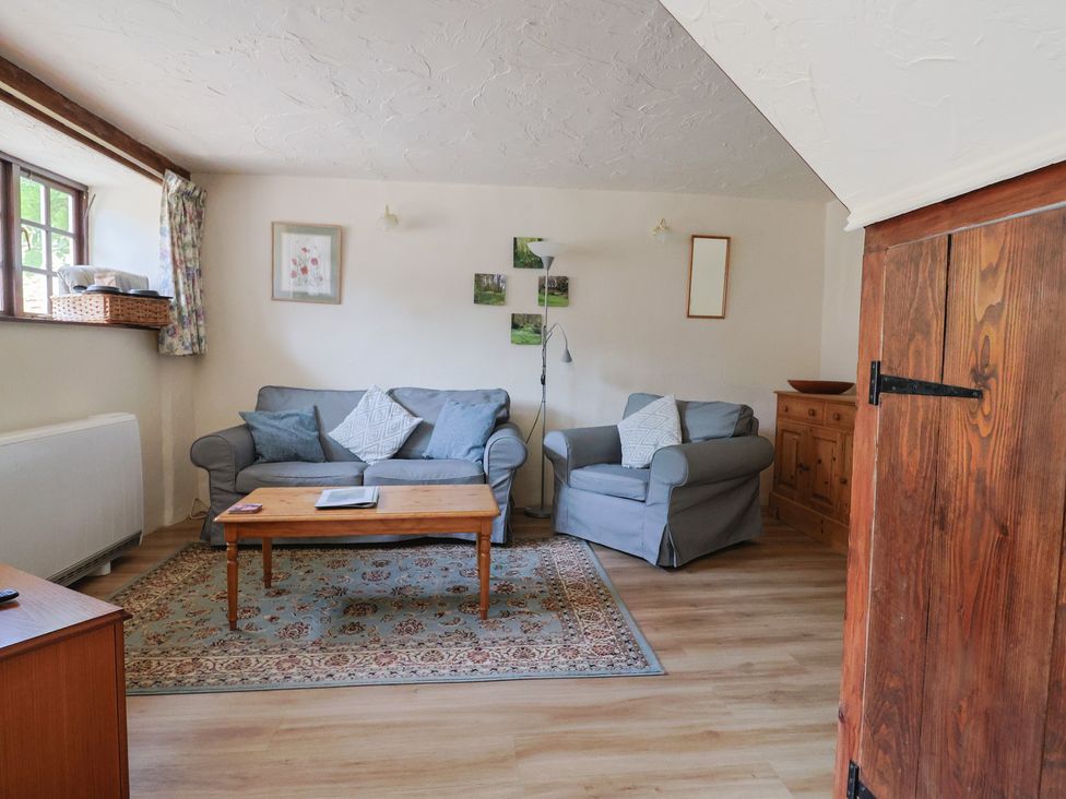 A living room with a sofa and armchair at The Old Bakery in South Perrott near Mosterton