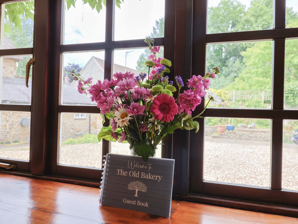 A flower vase and guest book on a window sill at The Old Bakery South Perrott near Mosterton