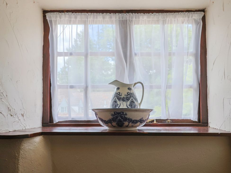 A window with a pitcher and bowl on the windowsill at The Old Bakery South Perrott near Mosterton