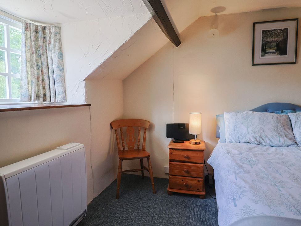 A bedroom with a bed and chair at The Old Bakery in South Perrott near Mosterton
