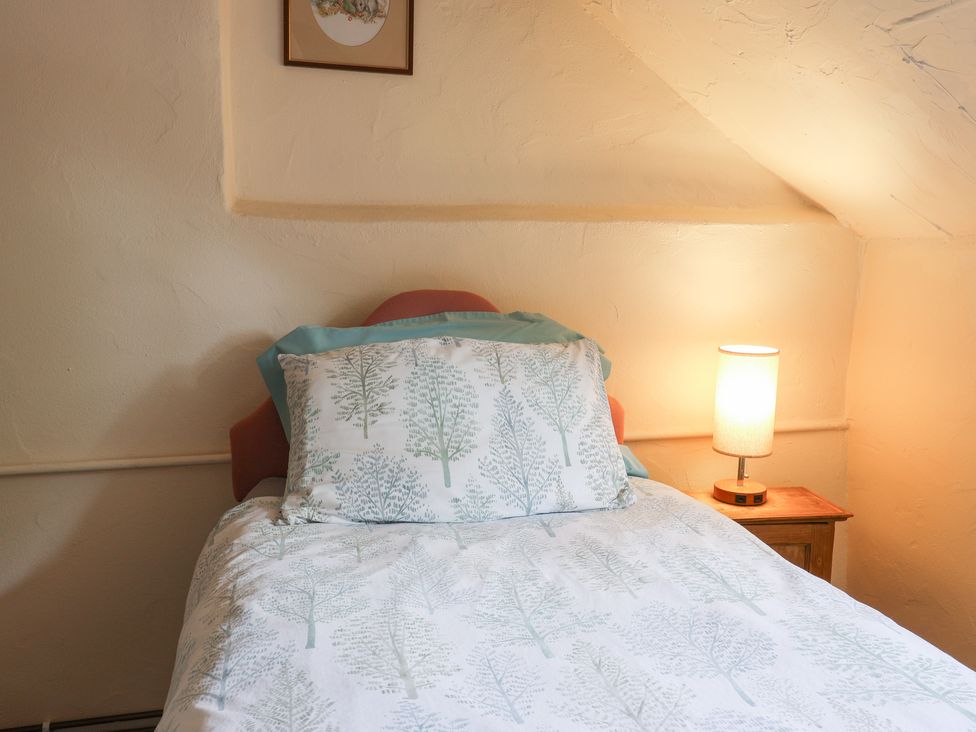 A bedroom with a bed and lamp at The Old Bakery in South Perrott near Mosterton