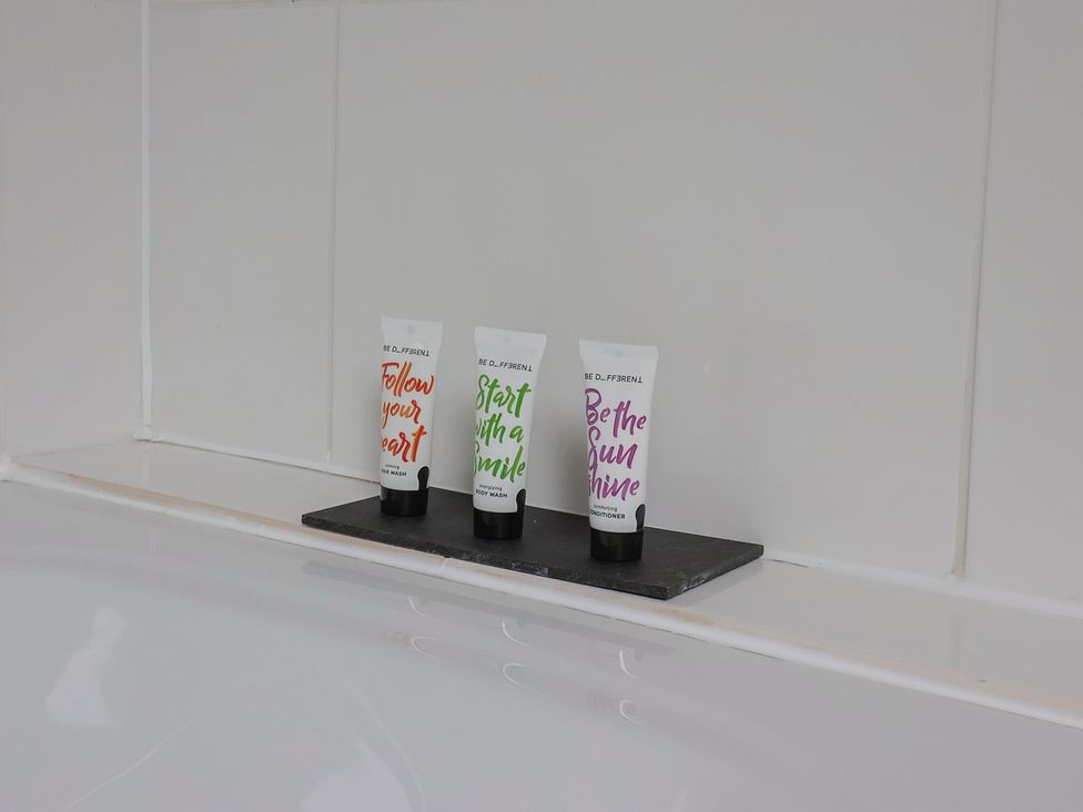 Body wash and conditioner tubes on a shelf in a bathroom at The Old Bakery South Perrott near Mosterton