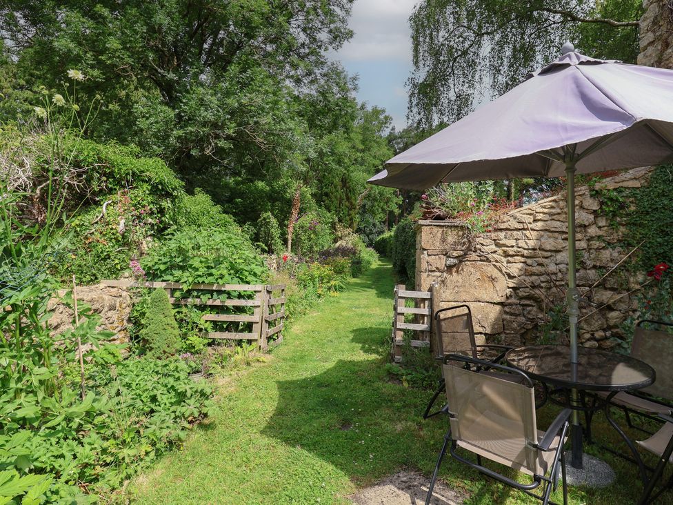 A garden with seating area and path at The Old Bakery South Perrott near Mosterton