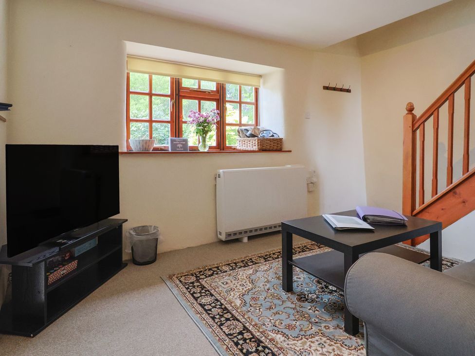 A living room with a television and a coffee table at Jasmine Cottage South Perrott near Mosterton