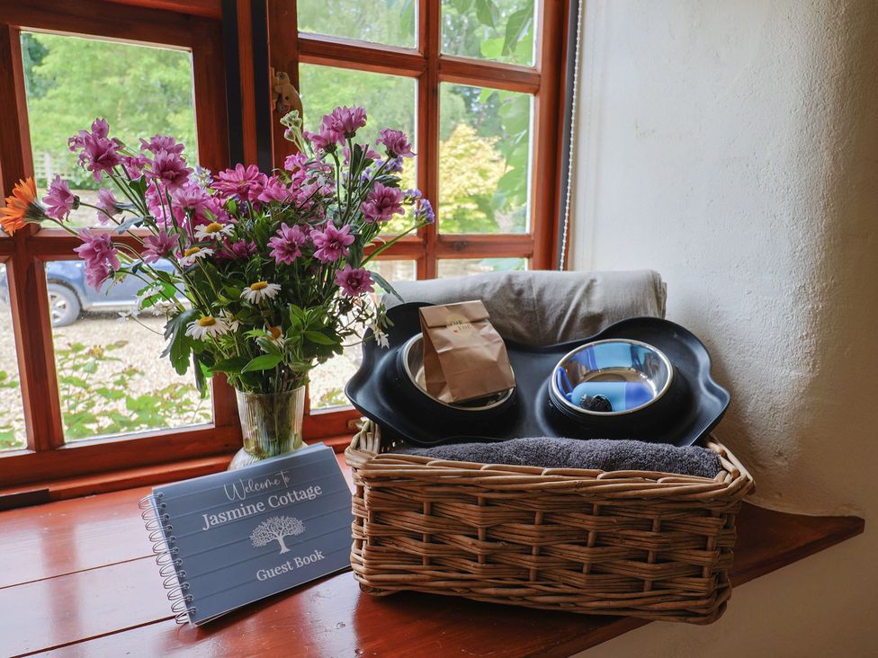 A basket with towels and bowls near a guest book at Jasmine Cottage in South Perrott near Mosterton