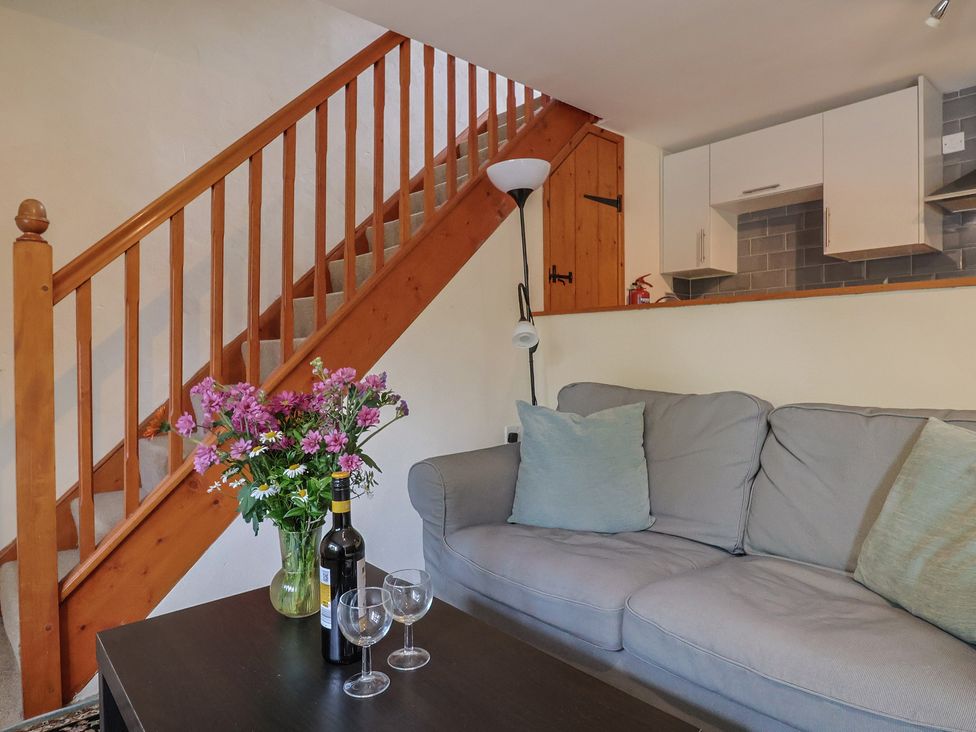 A living room with a staircase and a sofa at Jasmine Cottage South Perrott near Mosterton