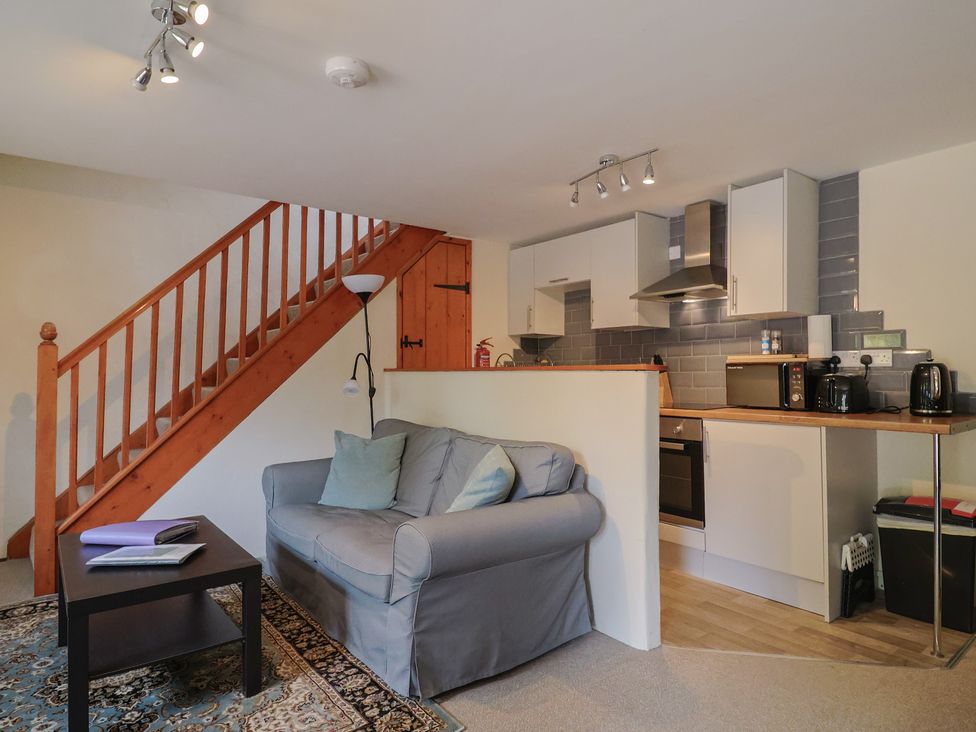 A living room with a sofa and kitchen units at Jasmine Cottage South Perrott near Mosterton
