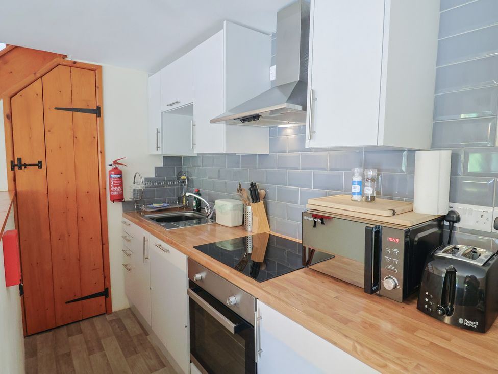 A kitchen with a stove and sink at Jasmine Cottage South Perrott near Mosterton