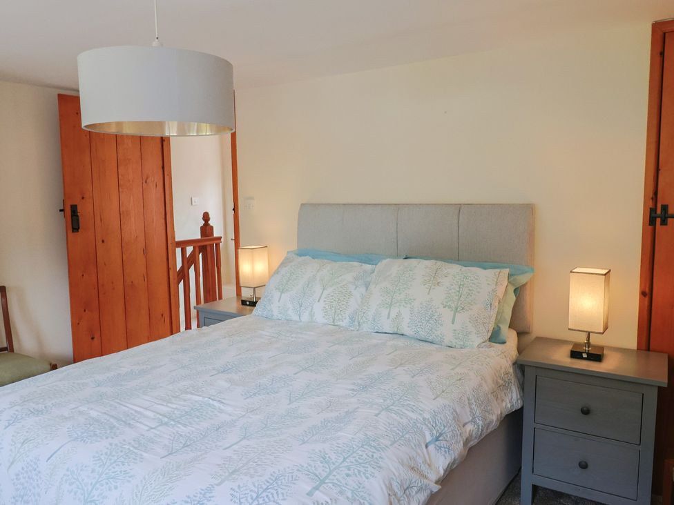 A bedroom with a bed and nightstand at Jasmine Cottage South Perrott near Mosterton