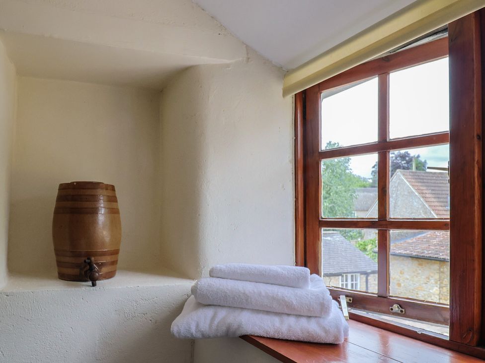 A bathroom with a wooden barrel and stacked towels at Jasmine Cottage South Perrott near Mosterton