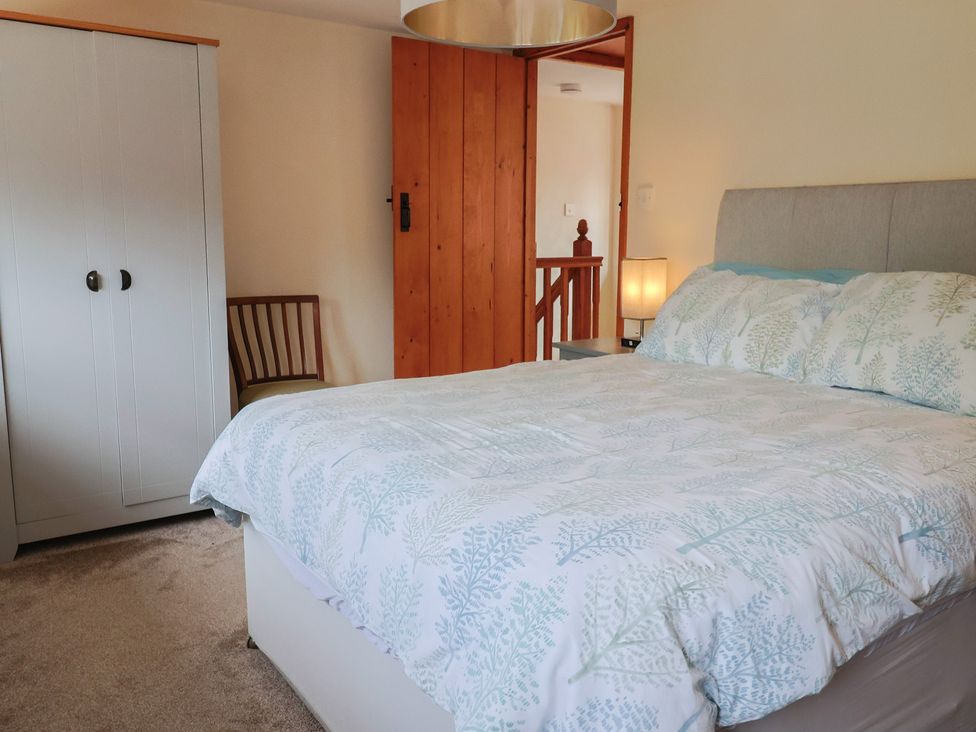 A bedroom with a bed and wardrobe at Jasmine Cottage South Perrott near Mosterton