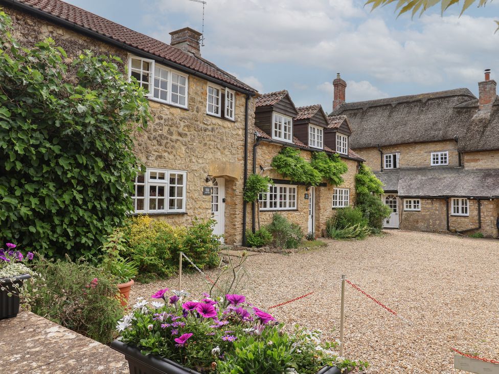 An outdoor area with stone cottages and a gravel driveway at Jasmine Cottage South Perrott near Mosterton
