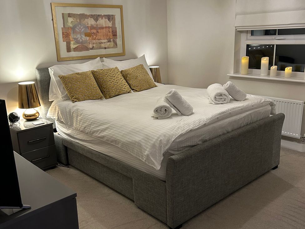 A bedroom with a bed, bedside table, and candles at The Green in Whitby