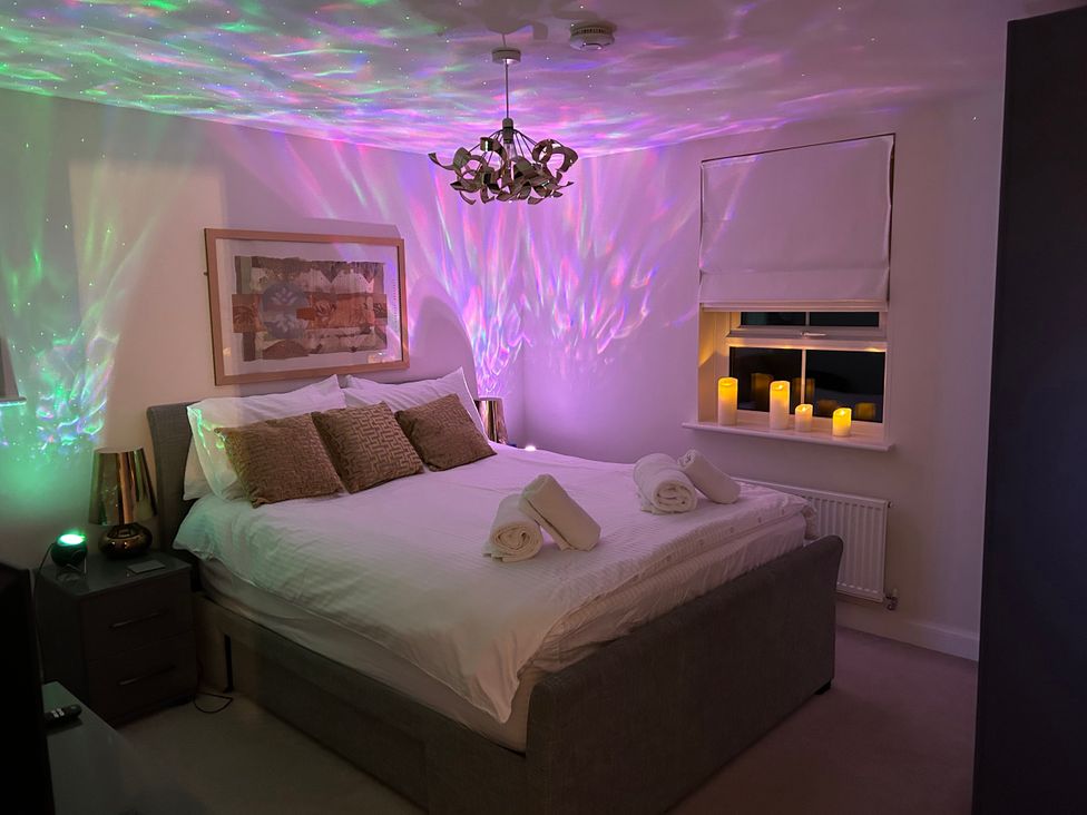 A bedroom with a bed and candles on the window sill at The Green in Whitby