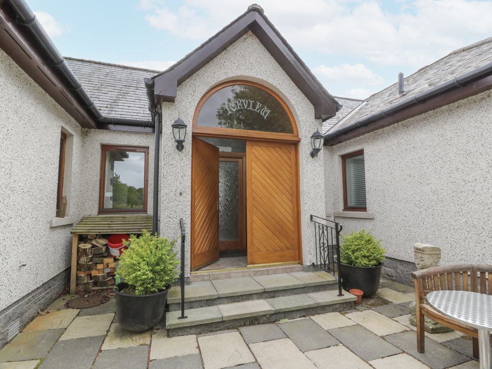 An entrance with a wooden door and potted plants at Torview House Lyne Station near Peebles