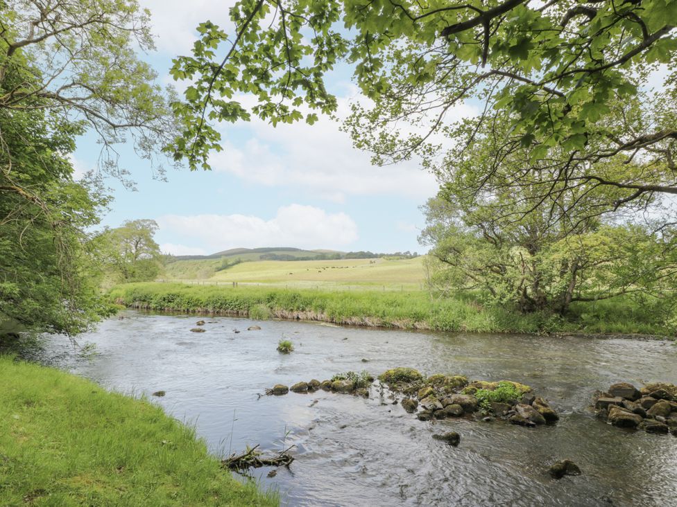 A river flowing through a grassy landscape at Torview House Lyne Station near Peebles