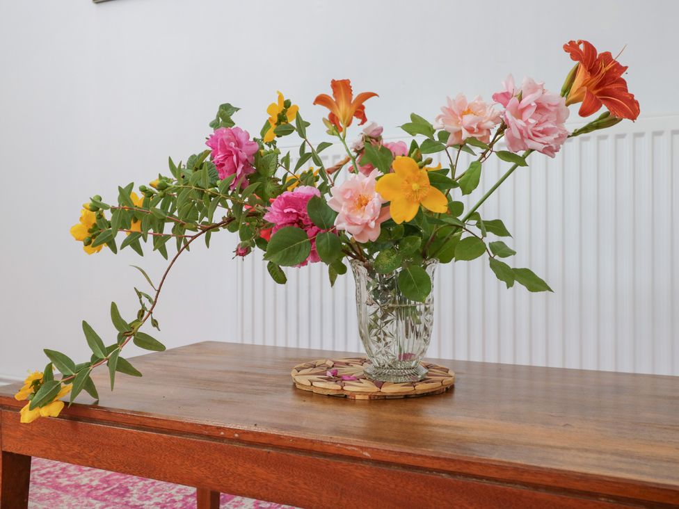 A vase with flowers on a table at Coach House in Swindon